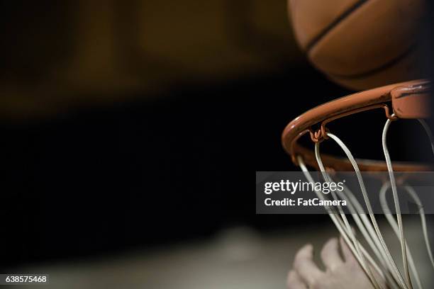 a basketball flying through the air and dropping into basketball hoop - basketball hoop stockfoto's en -beelden