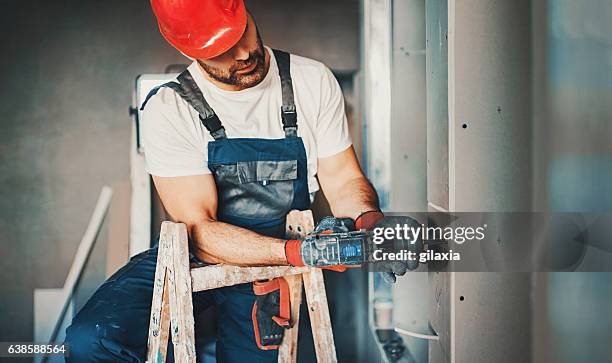 operaio edile durante il miglioramento della casa. - abbigliamento da lavoro foto e immagini stock