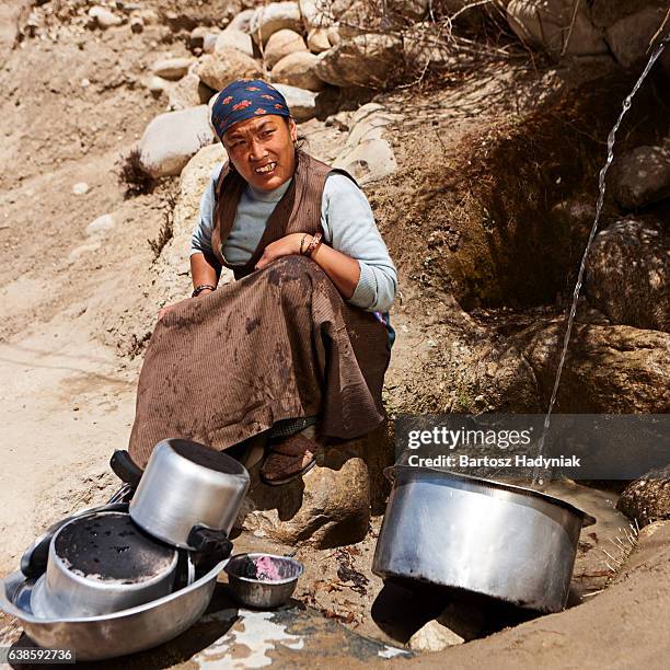 tibetan woman washing dishes. mustang - lo manthang 個照片及圖片檔