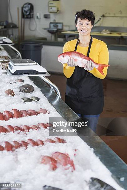 mixed race woman working in fish market - fish vendor bildbanksfoton och bilder