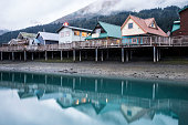 Colorful houses beneath fog and above water in Seward, Alaska.