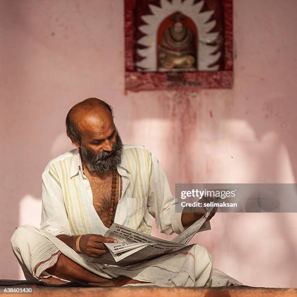 portrait of indian senior man reading newspaper - the hindu news stock pictures, royalty-free photos & images