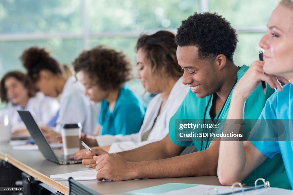 Diverse pre-med students take notes during class