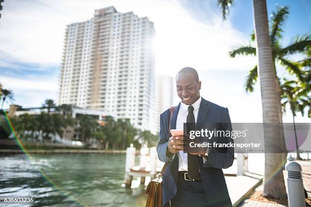 hombre de negocios enviando mensajes de texto en miami - city of miami fotografías e imágenes de stock