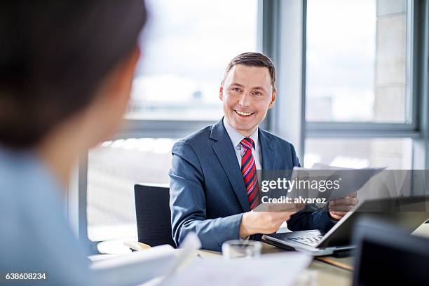 uomo d'affari sorridente che discute con il collega - governing board foto e immagini stock