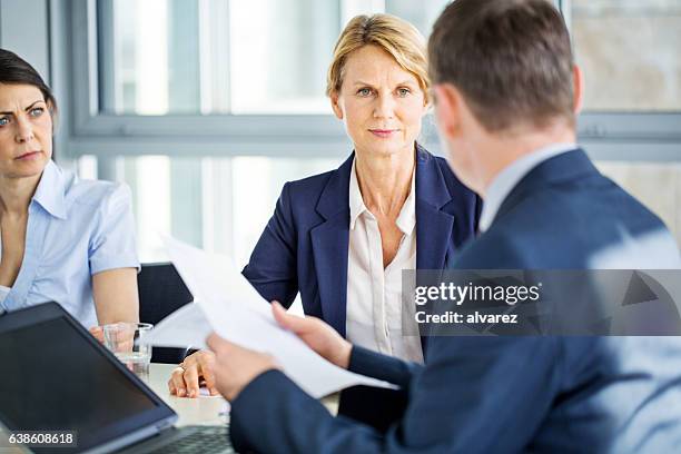 senior businesswoman während einer mitarbeiterbesprechung - verwaltungsrat stock-fotos und bilder