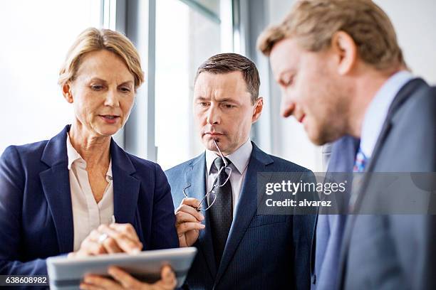 mature businesswoman viewing proposal to colleagues - bussines group suit tie stock pictures, royalty-free photos & images