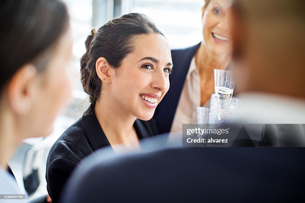 Happy businesswoman celebrating with colleagues in office