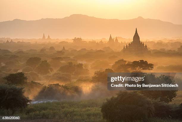 pagodas and the mist at sunset in bagan, mandalay, myanmar - bagan temples damaged in myanmar earthquake stock pictures, royalty-free photos & images