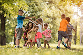 Group of small kids having fun while playing in nature.
