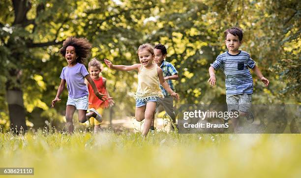 group of happy children having fun while running in nature. - happy runner stockfoto's en -beelden