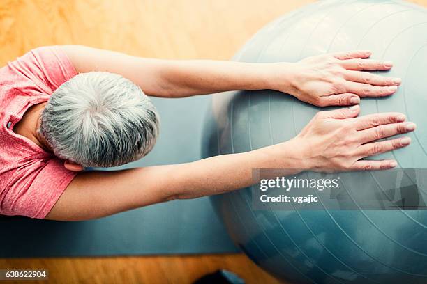 mature woman exercise at home. - yoga ball stock pictures, royalty-free photos & images