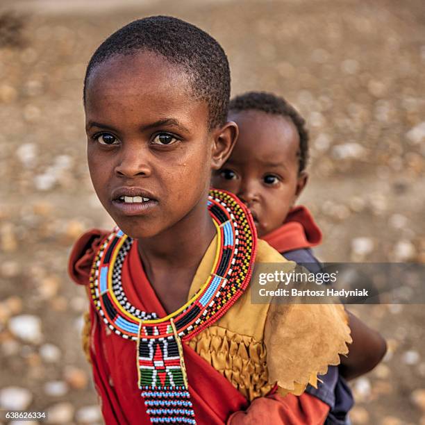 小さな女の子は彼女のアフリカ持ちの弟、ケニア、東アフリカ - samburu ストックフォトと画像