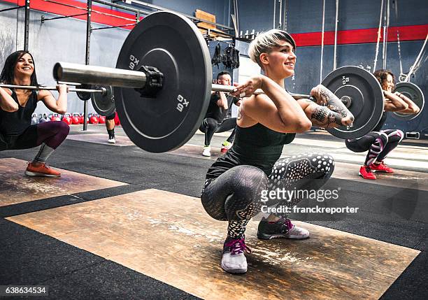 training class doing squat all together - snatch weightlifting stock pictures, royalty-free photos & images