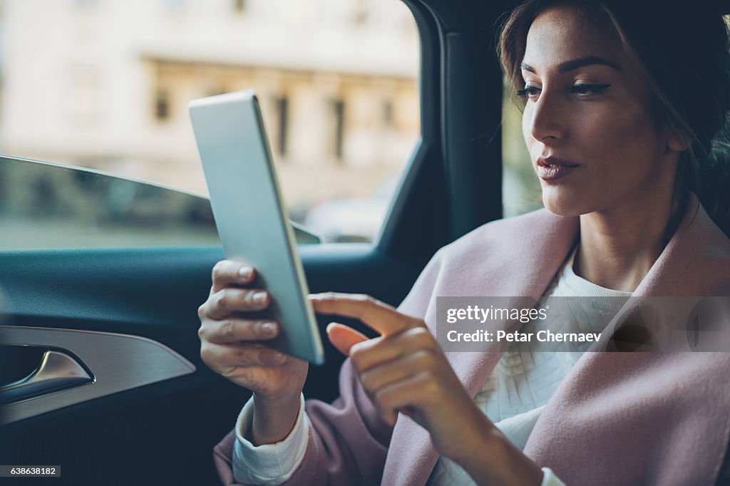 Woman with digital tablet in a car