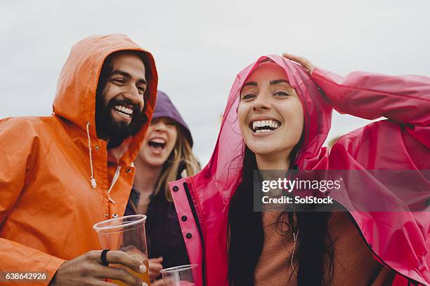 rainy festival days - raincoat stock-fotos und bilder