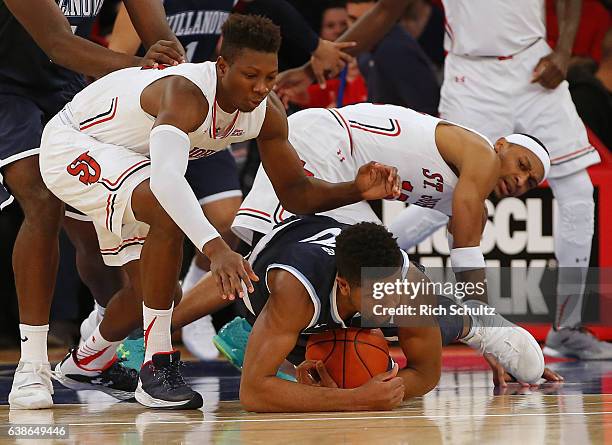 Kris Jenkins of the Villanova Wildcats dives on a loose ball between Kassoum Yakwe and Marcus LoVett of the St. John"u2019s Red Storm during the...