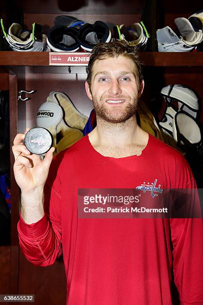 Karl Alzner of the Washington Capitals poses with a puck commemorating his 500th consecutive NHL game played after an NHL game against the Chicago...