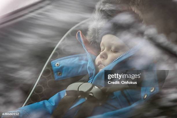 baby sleeping in car seat, wintersaison - winter car window stock-fotos und bilder