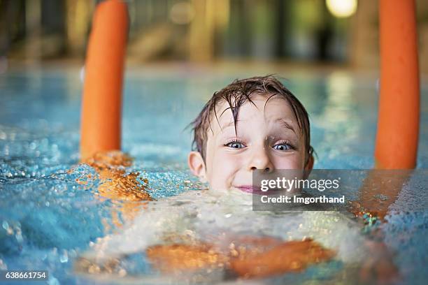 kleiner junge schwimmen lernen, nudeln mit pool - schwimmhilfe stock-fotos und bilder