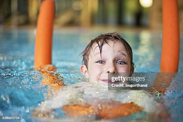 niño aprendiendo a nadar en la piscina con fideos - niño bañandose fotografías e imágenes de stock