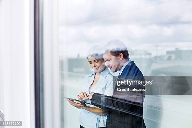 geschäftsleute im büro mit digitalem tablet - women at meeting stock-fotos und bilder
