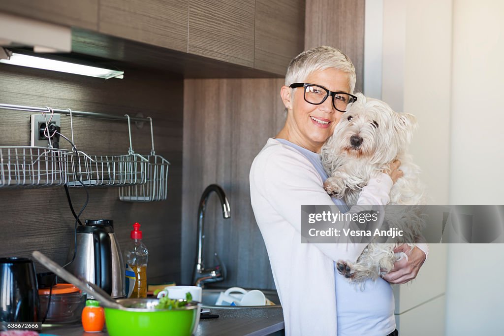 Reife Frau hält Hund zu Hause
