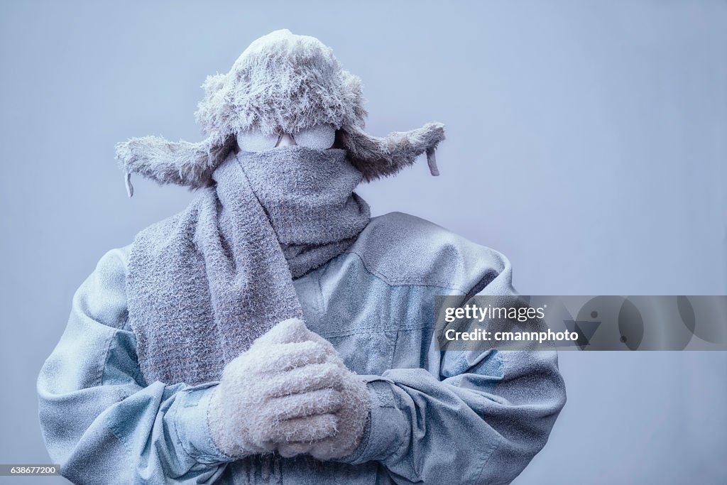 Man in parka, hat and scarf frozen from the cold