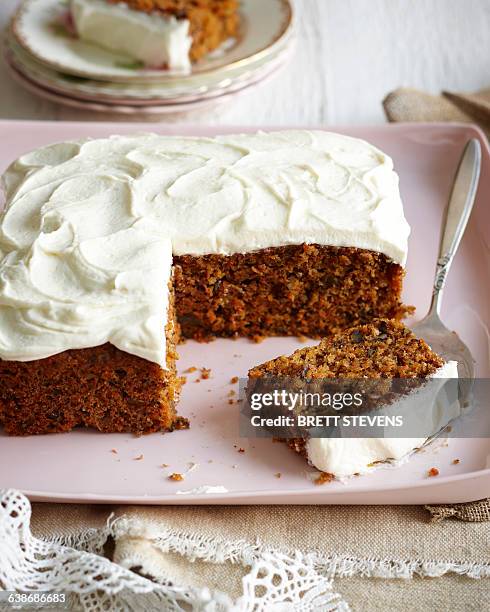 carrot cake with frosted icing on pink dish - carrot cake stock pictures, royalty-free photos & images