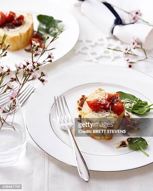 high angle view of goat cheese roulade with tomatoes and basil on elegant plate - appetizer stockfoto's en -beelden