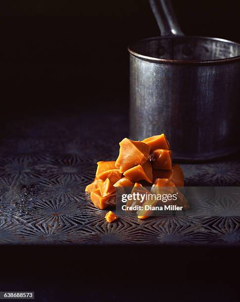 stack of home made toffee with metal saucepan - karamell stock-fotos und bilder