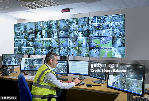 security guard in security control room with video wall - security cameras stock pictures, royalty-free photos & images