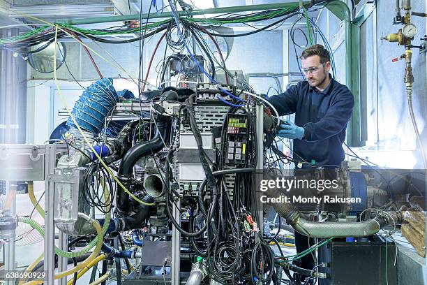engineer with car engine in testing bay of automotive parts factory - check engine stock pictures, royalty-free photos & images