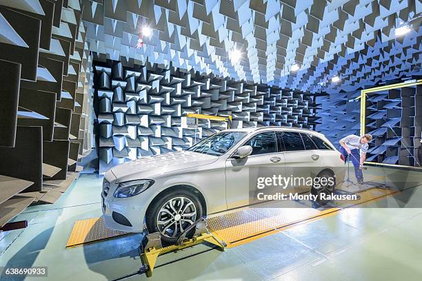 engineer testing vehicle on rolling road in anechoic chamber - auto industry stock pictures, royalty-free photos & images