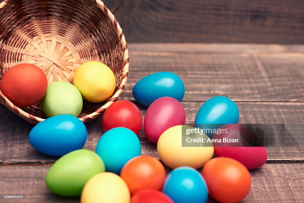 Easter eggs spilling out of their basket onto a wooden table. Debica, Poland