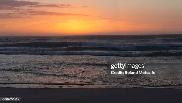 the sun sinks below the horizon, sunset, long beach, noordhoek, cape town, western cape, south africa. - noordhoek stock-fotos und bilder