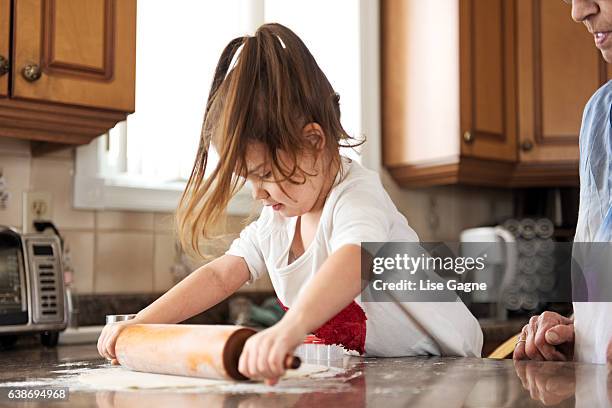 little girl making cookies with grandma - lise gagne stock pictures, royalty-free photos & images