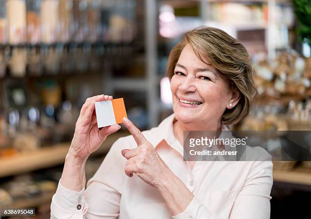 happy woman pointing at a business card - loyalty card bildbanksfoton och bilder