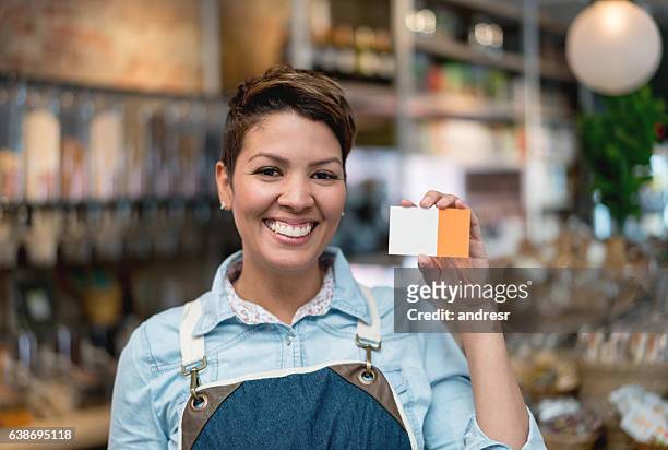business owner holding a business card - loyalty cards stock pictures, royalty-free photos & images