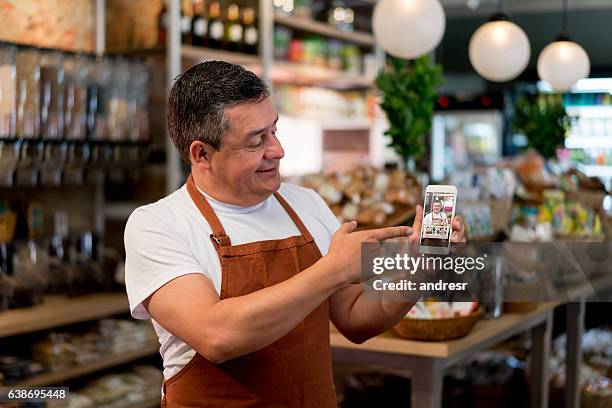 business owner selling food online at a grocery store - display stockfoto's en -beelden