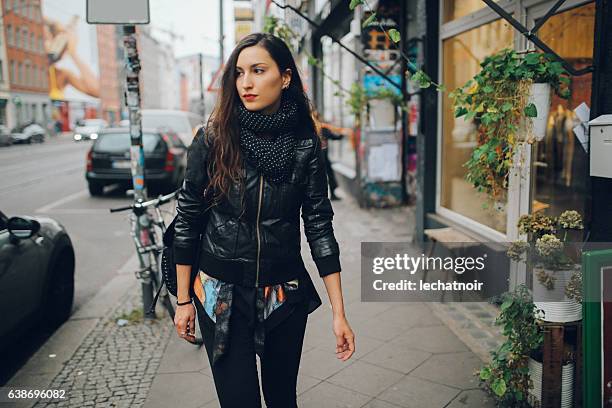 portrait of a young woman walking in berlin schoeneberg district - leather jacket stock pictures, royalty-free photos & images