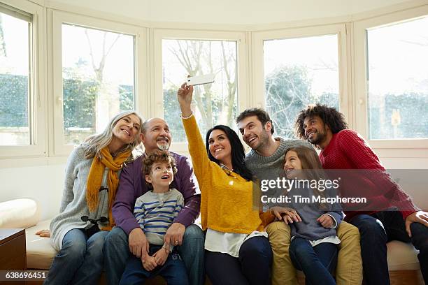 multi generation family on window seat using smartphone to take selfie - side by side imagens e fotografias de stock