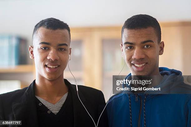 portrait of twin brothers, sharing earphones - identical twin stock pictures, royalty-free photos & images