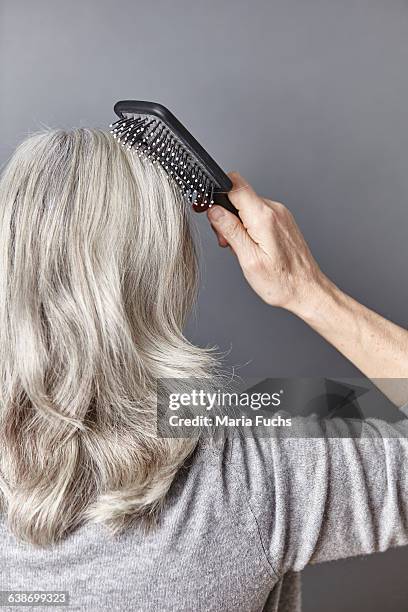 rear view of woman brushing long gray hair - brush in woman's hair imagens e fotografias de stock