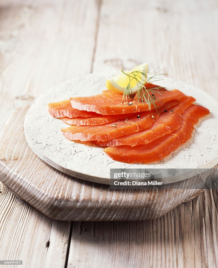 Smoked salmon slices with black pepper, dill and lemon