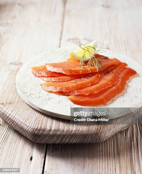 smoked salmon slices with black pepper, dill and lemon - dill fotografías e imágenes de stock