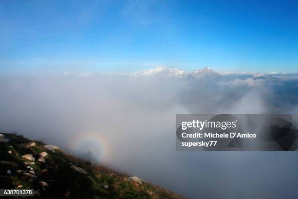 brocken spectre on the lombard alps - brocken spectre stock pictures, royalty-free photos & images