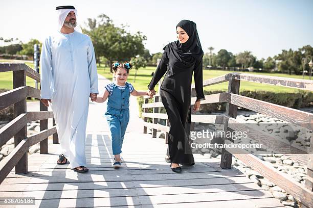 glücksfamilie zu fuß im park in dubai - burj khalifa stock-fotos und bilder