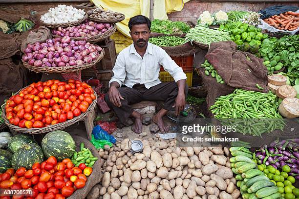 indian greengrocer sitting in his store and waiting for customers - indian shopkeeper stock pictures, royalty-free photos & images