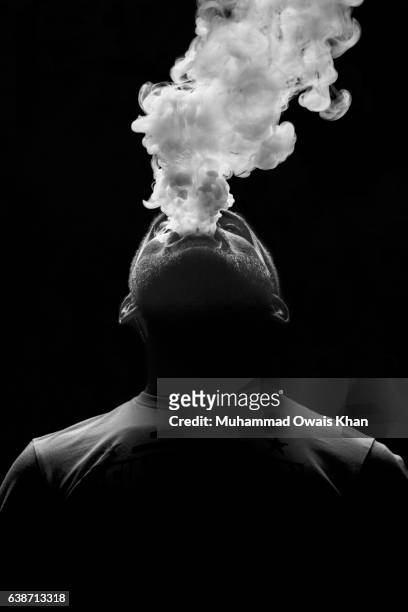 man breathing out smoke - electronic cigarette smoke ストックフォトと画像